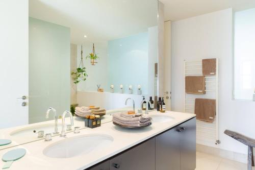 a white bathroom with two sinks and a shower at Architectural Home, Pool Oasis/ Steps from Trendy Chapel St. in Melbourne