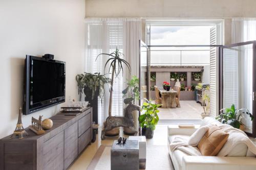 a living room with a couch and a tv at Architectural Home, Pool Oasis/ Steps from Trendy Chapel St. in Melbourne