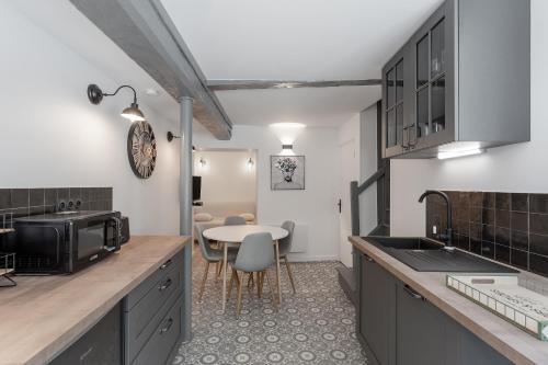 une cuisine avec un évier et une table avec des chaises dans l'établissement Un petit coin de Moyen Âge, à Beauvais