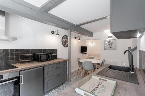 une cuisine avec un évier et une table avec des chaises dans l'établissement Un petit coin de Moyen Âge, à Beauvais