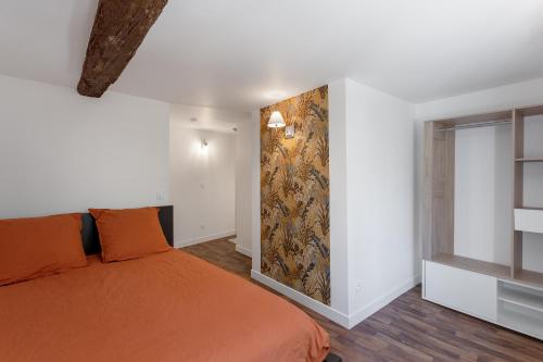 uma cama laranja num quarto branco com uma janela em Un petit coin de Moyen Âge em Beauvais