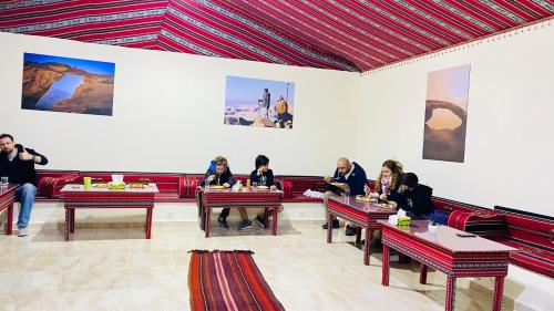a group of people sitting at tables in a restaurant at Rum Jordan camp and tours in Wadi Rum