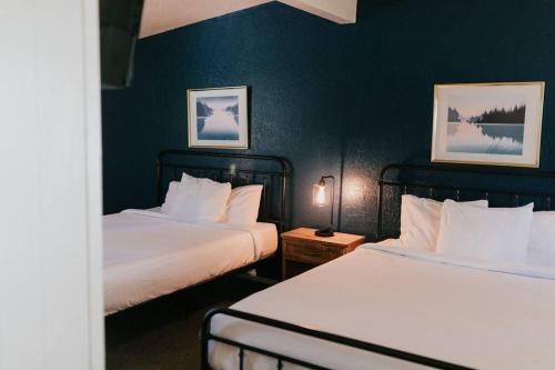 two beds in a hotel room with blue walls at The Long Barn Lodge in Long Barn