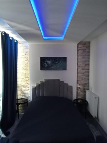 - une chambre avec une lumière bleue au plafond dans l'établissement Le Loft Toulouse Saint Cyprien - Studio Métro 3 mn, à Toulouse