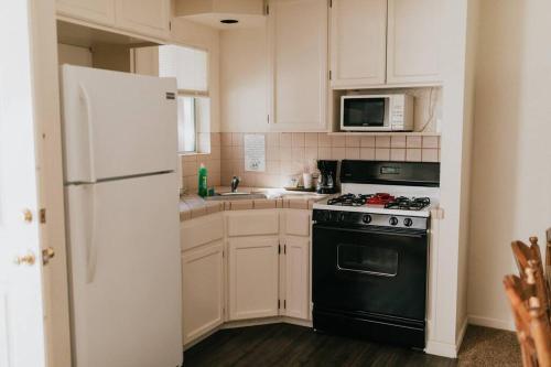 a kitchen with a black stove and a white refrigerator at The Long Barn Lodge in Long Barn