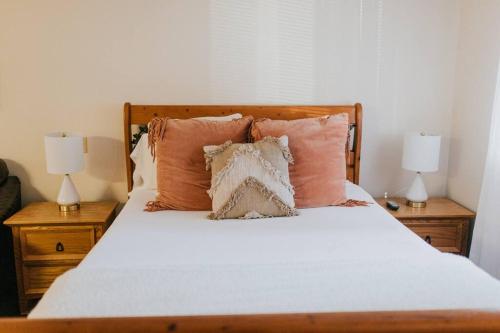 a bedroom with a bed with pillows and two lamps at The Long Barn Lodge in Long Barn