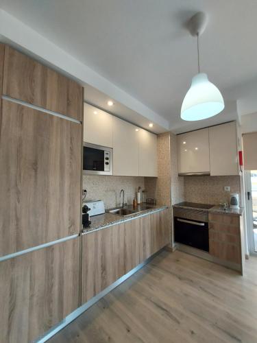 a large kitchen with wooden cabinets and a large refrigerator at Elite Residence Praia da Rocha in Portimão