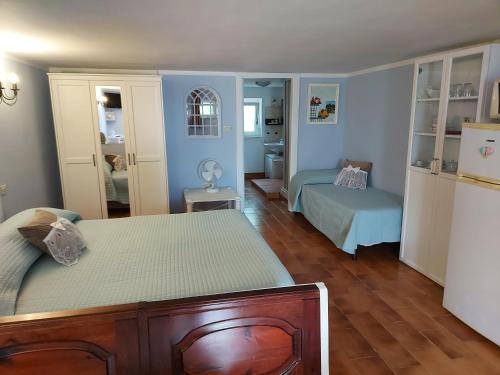 a bedroom with two beds and a refrigerator in it at Casa Vacanza Fiori di Maggio in Pulsano