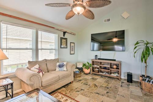 a living room with a couch and a flat screen tv at Pool Access and Walk to Beach Galveston Home in Galveston
