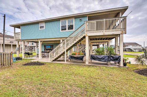 a blue house with a porch with two chairs at Pool Access and Walk to Beach Galveston Home in Galveston