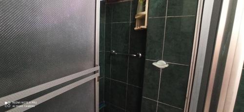 um chuveiro com uma porta de vidro e um WC em Departamento Marlene em Cuenca