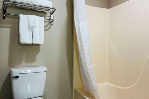 a bathroom with a white toilet and towels at Super 8 by Wyndham Pratt in Pratt