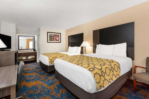 A bed or beds in a room at Baymont by Wyndham Tallahassee