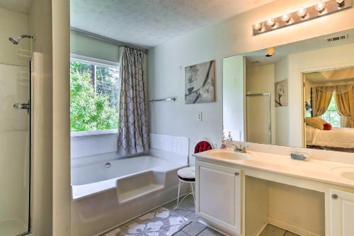 uma casa de banho com uma banheira, um lavatório e um espelho. em Pet-Friendly Home with Yard about 15 Mi to Atlanta! em Fairington