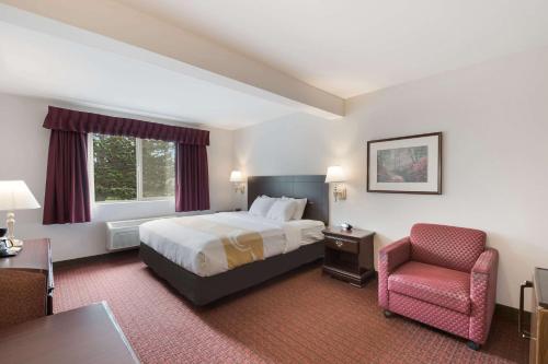 ベリンガムにあるQuality Inn Grand Suites Bellinghamのベッドと椅子付きのホテルルーム