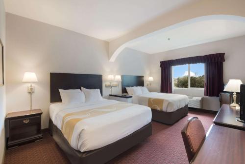 a hotel room with two beds and a window at Quality Inn Grand Suites Bellingham in Bellingham