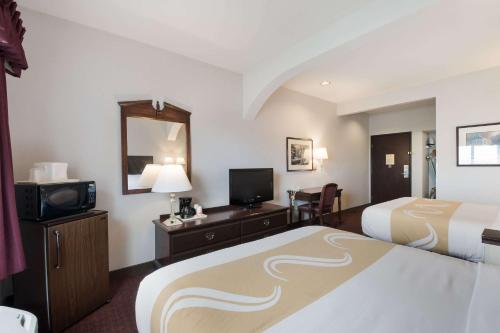 a hotel room with two beds and a television at Quality Inn Grand Suites Bellingham in Bellingham