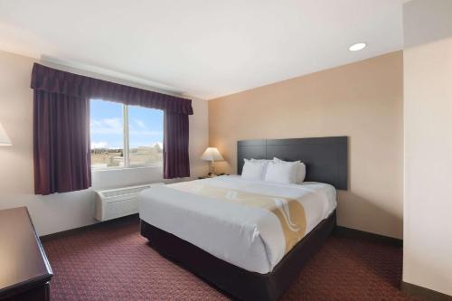 a hotel room with a large bed and a window at Quality Inn Grand Suites Bellingham in Bellingham