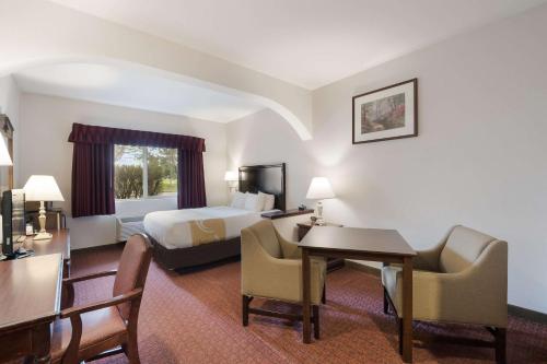 a hotel room with a bed and a desk at Quality Inn Grand Suites Bellingham in Bellingham