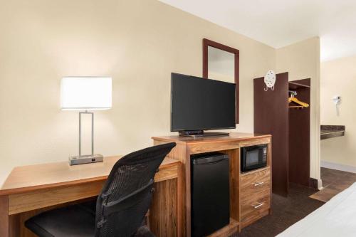 a room with a desk with a television and a chair at Luxe Studios Nashville Airport in Nashville