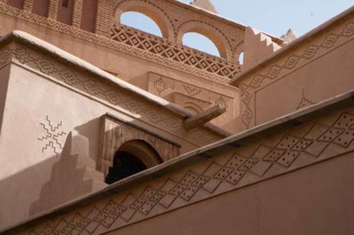 a building with a window on the side of it at Kasbah Hotel Ait Omar in Nkob