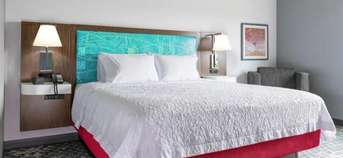 una habitación de hotel con una cama grande y una silla en Hampton Inn West Wichita Goddard, en Goddard