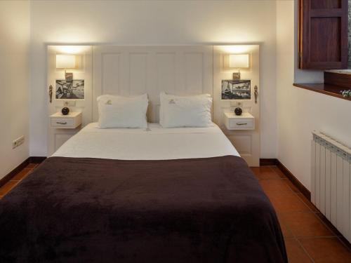 Casa de Sequiade في Sequeade: غرفة نوم بسرير كبير مع مواقف ليلتين