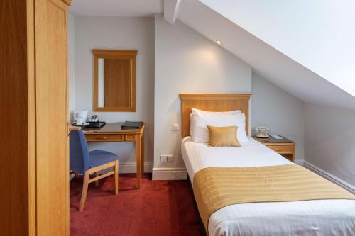 a hotel room with a bed and a desk and a bed and a chair at New Continental Hotel; Sure Hotel Collection by Best Western in Plymouth