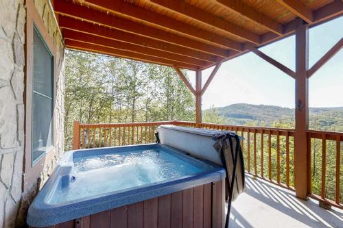 a hot tub sitting on a deck with a balcony at Eagles Nest in New Tazewell