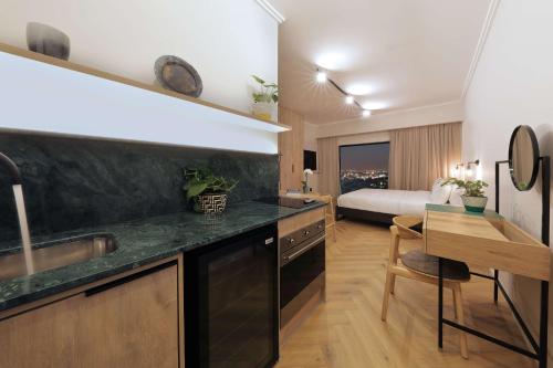 a kitchen with a sink and a room with a bed at Hyatt House Johannesburg, Sandton in Johannesburg