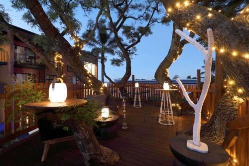 a deck with lights and tables and a tree at Hyatt House Johannesburg, Sandton in Johannesburg