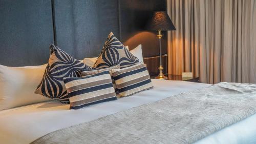 a bed with four pillows on it with at Grand Papua Hotel, a member of Radisson Individuals in Port Moresby
