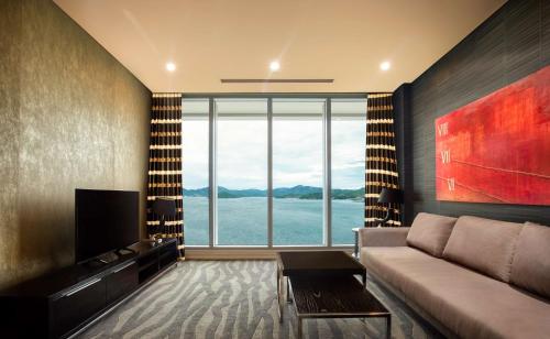 a living room with a couch and a large window at Grand Papua Hotel, a member of Radisson Individuals in Port Moresby
