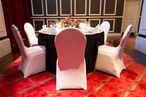a table with white chairs and a black and white table cloth at Grand Papua Hotel, a member of Radisson Individuals in Port Moresby