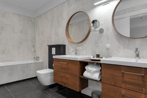 
a bathroom with a toilet a sink and a mirror at Hotel Grimsborgir - Your Golden Circle Retreat in Ásborgir
