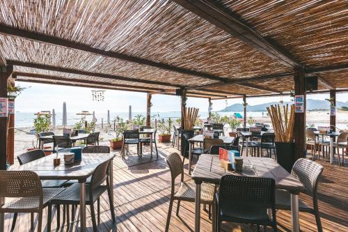 a restaurant with tables and chairs on a deck at Domoemare in Siniscola