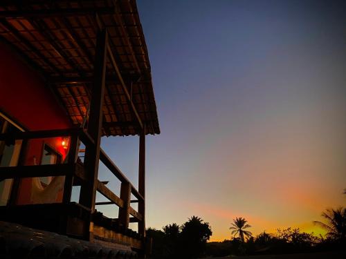 een zonsondergang achter een gebouw met de hemel op de achtergrond bij Pousada Fasani in Ilha de Boipeba