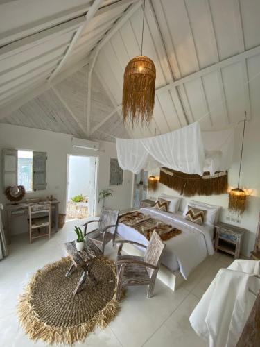 a large bedroom with a large bed and a chandelier at Atalaya Villas Nusa Penida in Nusa Penida