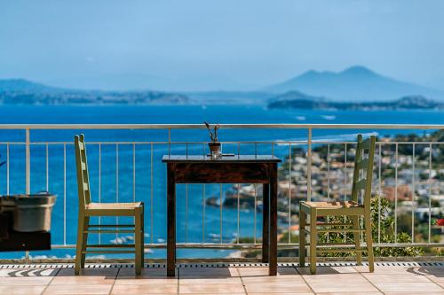 a table and chairs on a balcony with a view of the ocean at Paradise Relais Villa Janto' in Ischia