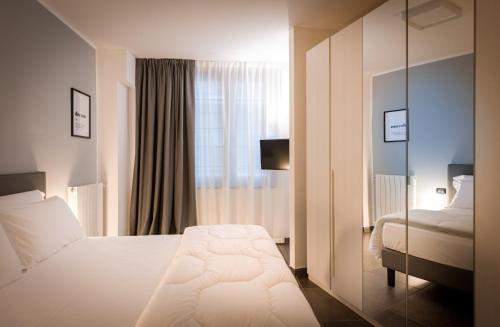 Pokój hotelowy z łóżkiem i lustrem w obiekcie TURINHOMETOWN Residence Apartments w Turynie