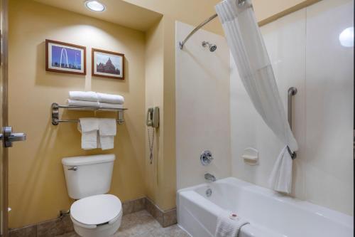 a bathroom with a toilet and a tub and a shower at Comfort Suites DFW Airport in Irving
