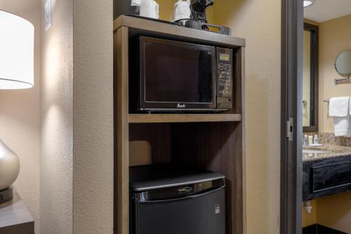 a microwave on a shelf in a hotel room at Comfort Suites DFW Airport in Irving