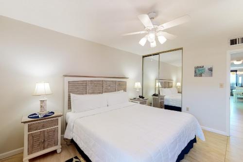 a bedroom with a white bed and a ceiling fan at Jetty East Condos II in Destin
