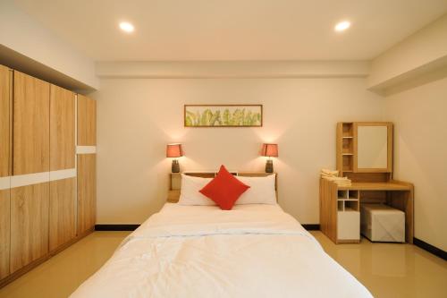 1 dormitorio con 1 cama blanca grande con almohadas rojas en U Sabai Hotel Bangkok, en Bangkok