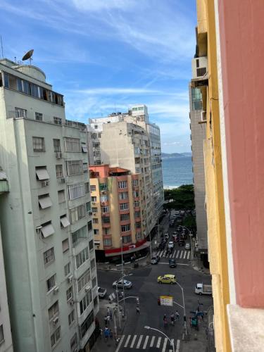 Blick auf eine Stadtstraße mit Gebäuden und das Meer in der Unterkunft Copacabana Posto 6 in Rio de Janeiro