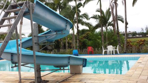 a blue slide next to a swimming pool at Hotel Marina Clube de Pesca in Cananéia