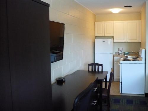a kitchen with a counter and a white refrigerator at Westgate Inn in Portage La Prairie