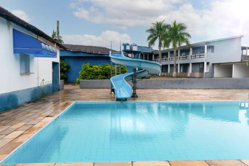 a blue slide in the middle of a swimming pool at Hotel Marina Clube de Pesca in Cananéia