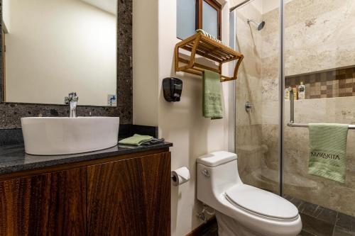 a bathroom with a toilet and a sink and a shower at Villa with ocean view, pool, restaurant and rooftop in Isla Mujeres