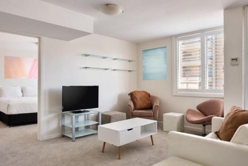 a living room with a tv and a couch at Heart Of Manly and Close to Everything in Sydney